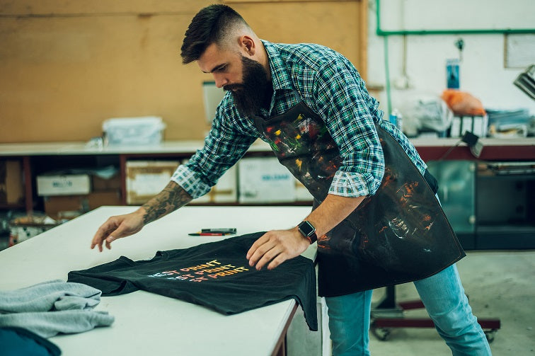 man folding recently pressed t-shirt